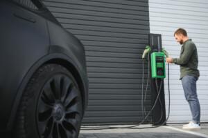 a man stands near a charging station and charges h 2025 03 31 04 19 43 utc