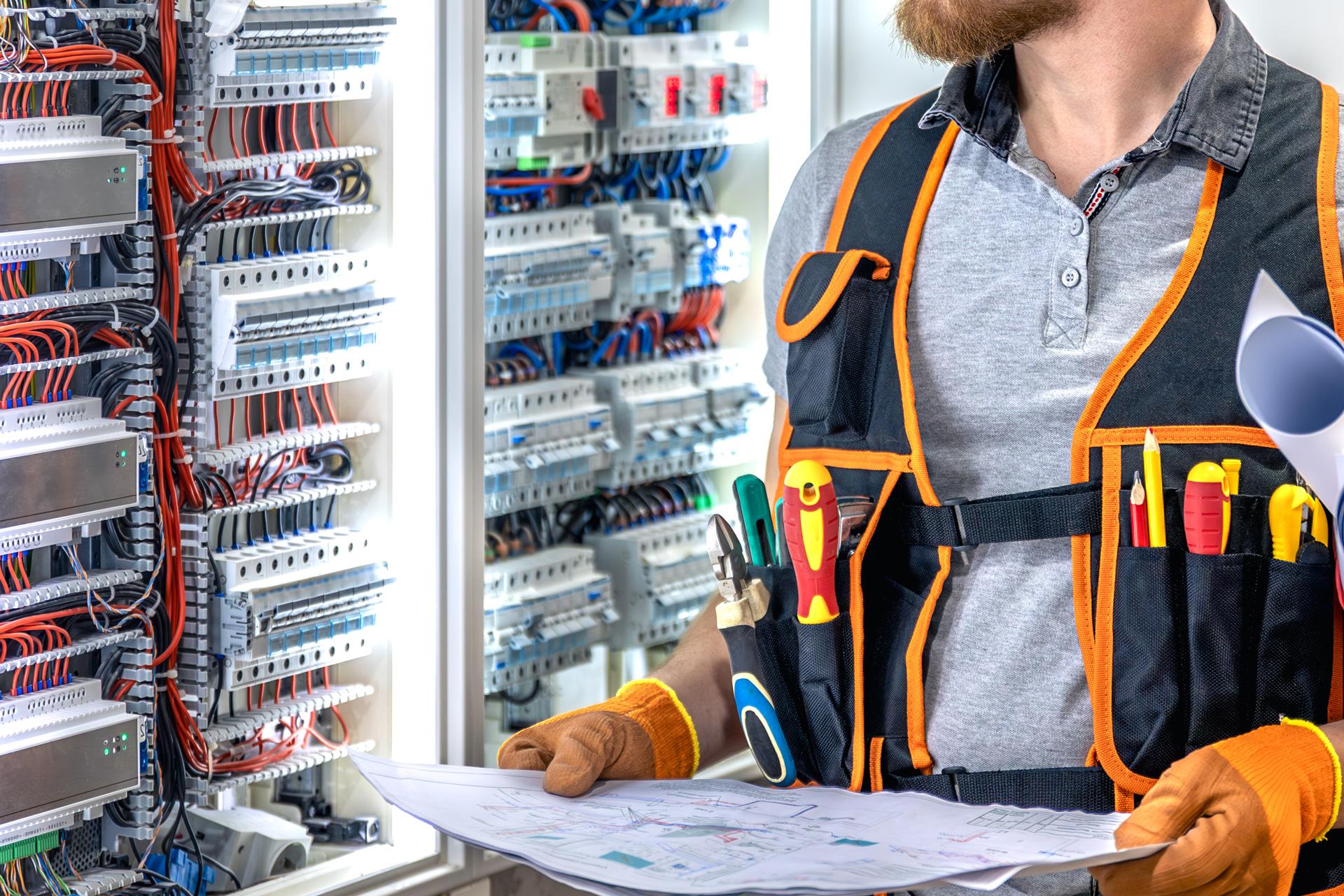 Gebäudetechnik Dech - Mann mit Plan vor Schalterkasten